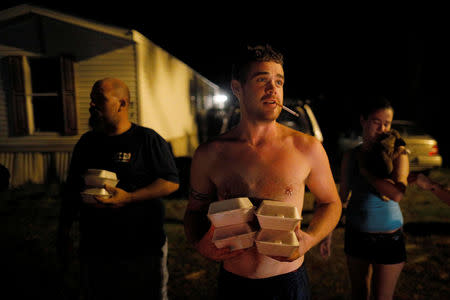 Chris Bailey holds hot food prepared by Operation BBQ Relief and distributed by 50 Star Search and Rescue following Hurricane Michael in Panama City Beach, Florida, U.S., October 15, 2018. REUTERS/Brian Snyder