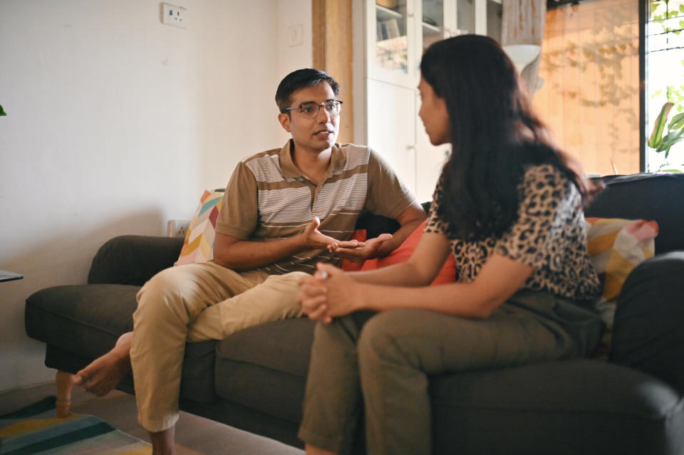 A couple talking seriously on the couch