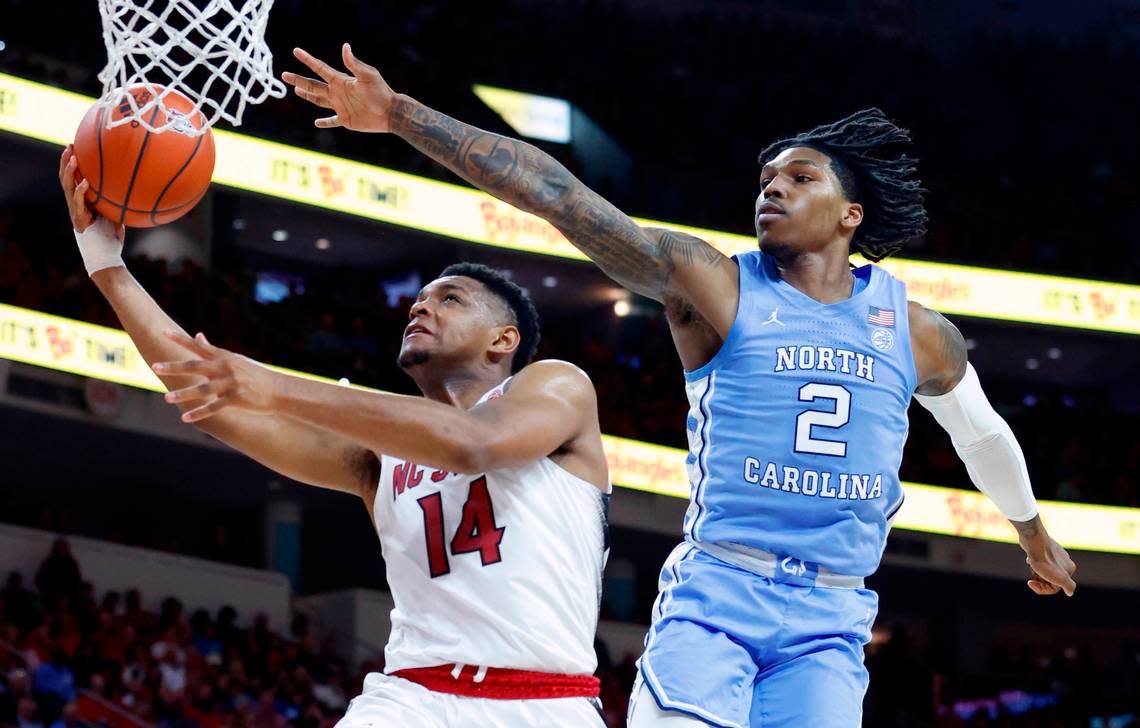 N.C. State’s Casey Morsell (14) heads to the basket as North Carolina’s Caleb Love (2) defends during the second half of N.C. State’s 77-69 victory over UNC at PNC Arena in Raleigh, N.C., Sunday, Feb. 19, 2023.