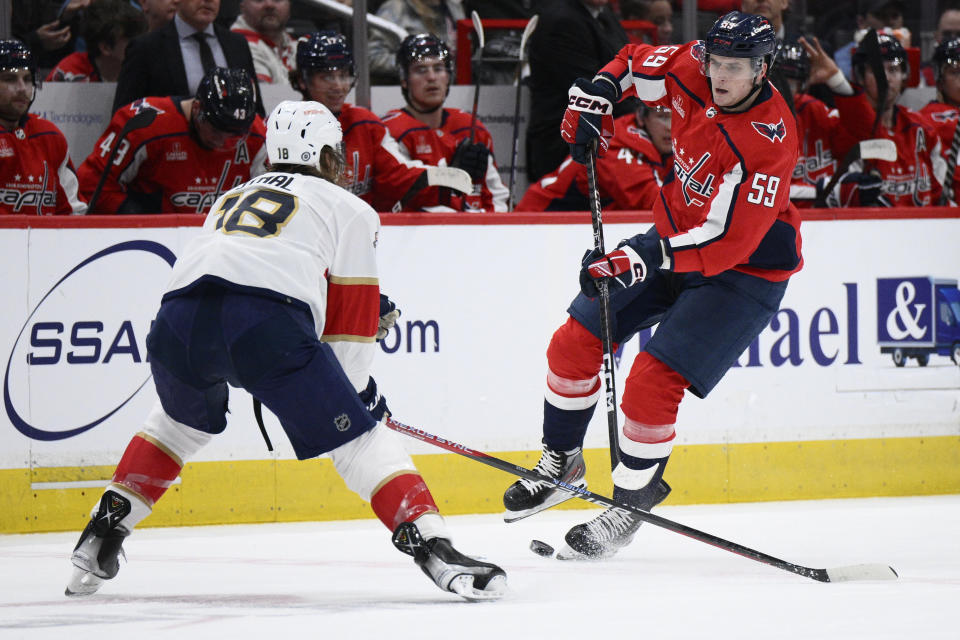 Washington Capitals center Aliaksei Protas (59) passes the puck against Florida Panthers defenseman Marc Staal (18) during the first period of an NHL hockey game, Saturday, April 8, 2023, in Washington. (AP Photo/Nick Wass)