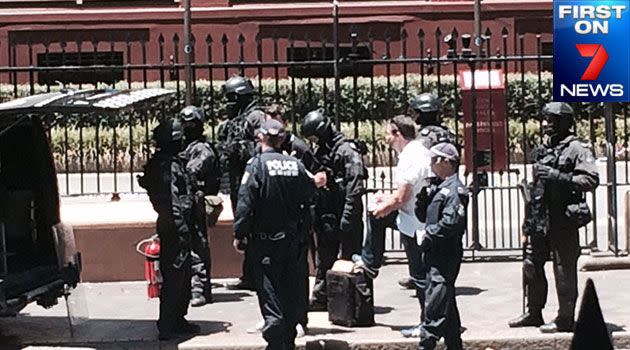 The riot squad outside NSW Parliament House negotiate with the man who refused to get out of a white Chrysler sedan. Photo: FIRST ON 7