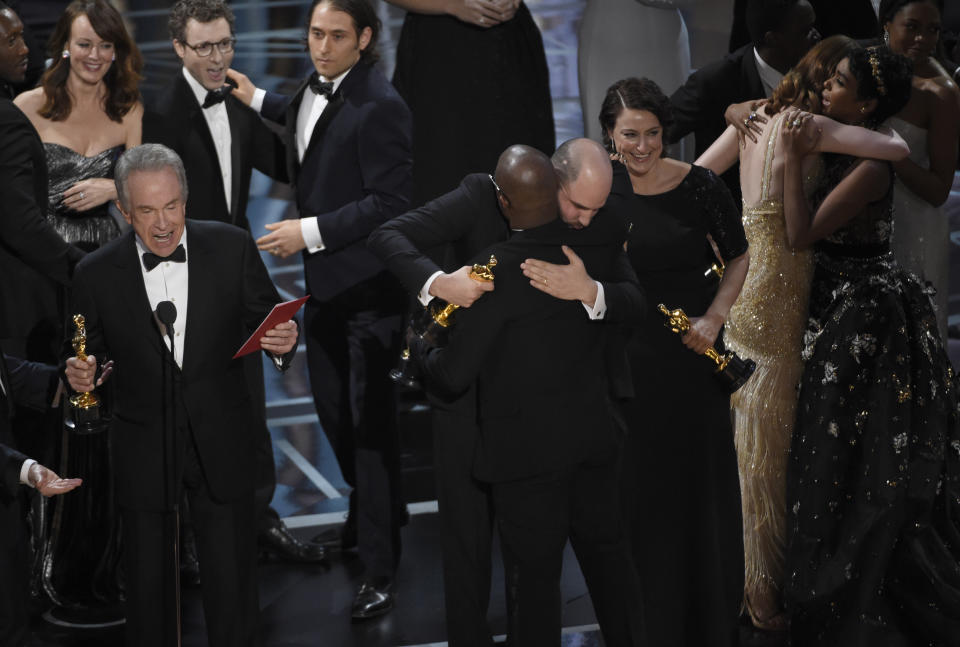 Warren Beatty clarifies the 2017 Best Picture flub while "La La Land" producer Jordan Horowitz and "Moonlight" director Barry Jenkins hug. (Photo: Chris Pizzello/Invision/AP)