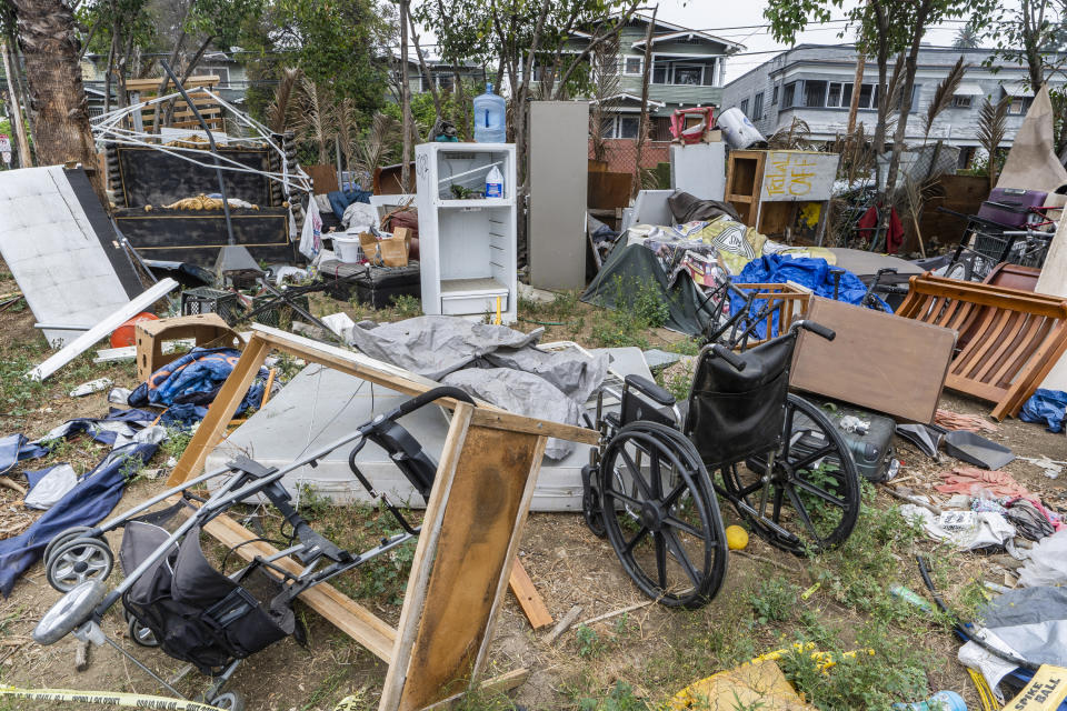 A trashed wheel chair is seen on a homeless encampment on the side of the CA-101 highway in Echo Park neighborhood in Los Angeles Tuesday, May 11, 2021. California Gov. Gavin Newsom on Tuesday proposed $12 billion in new funding to get more people experiencing homelessness in the state into housing and to “functionally end family homelessness” within five years. (AP Photo/Damian Dovarganes)