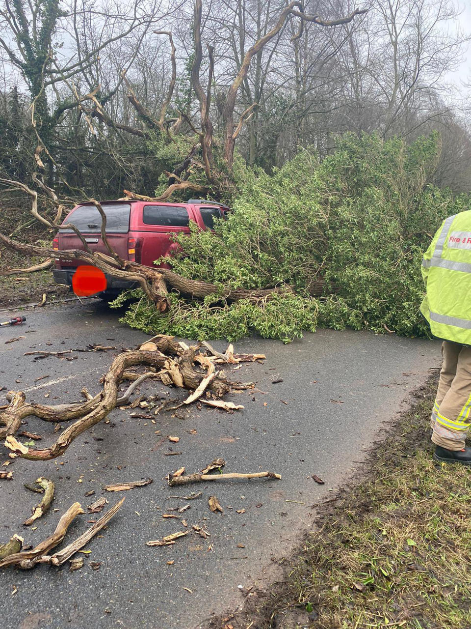 A vehicle trapped under a fallen tree in Brewood. Two people were treated for minor injuries. (PA)