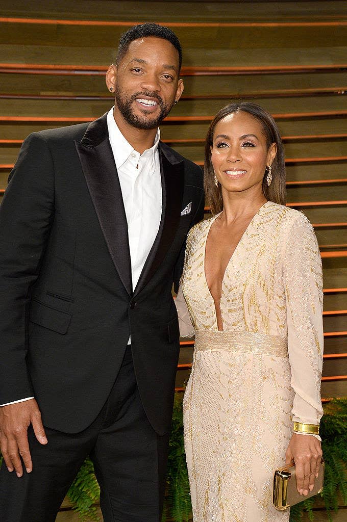 The couple smiling at a red carpet event