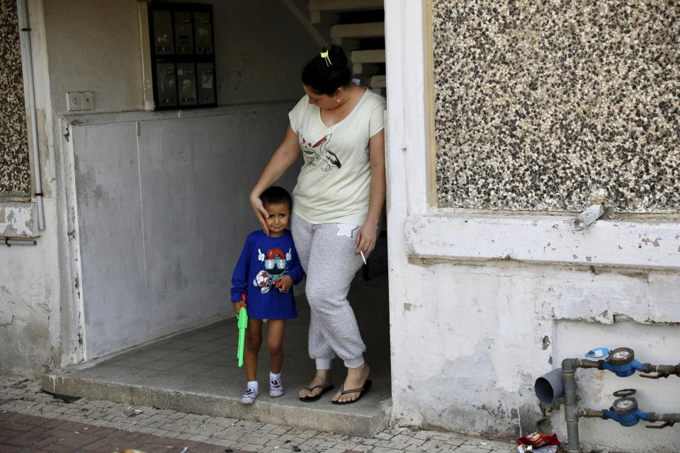 A woman comforts her son after air raid sirens sounded for incoming rockets from Gaza, in Sderot, southern Israel, Wednesday, Nov. 13, 2019. (AP Photo/Ariel Schalit)