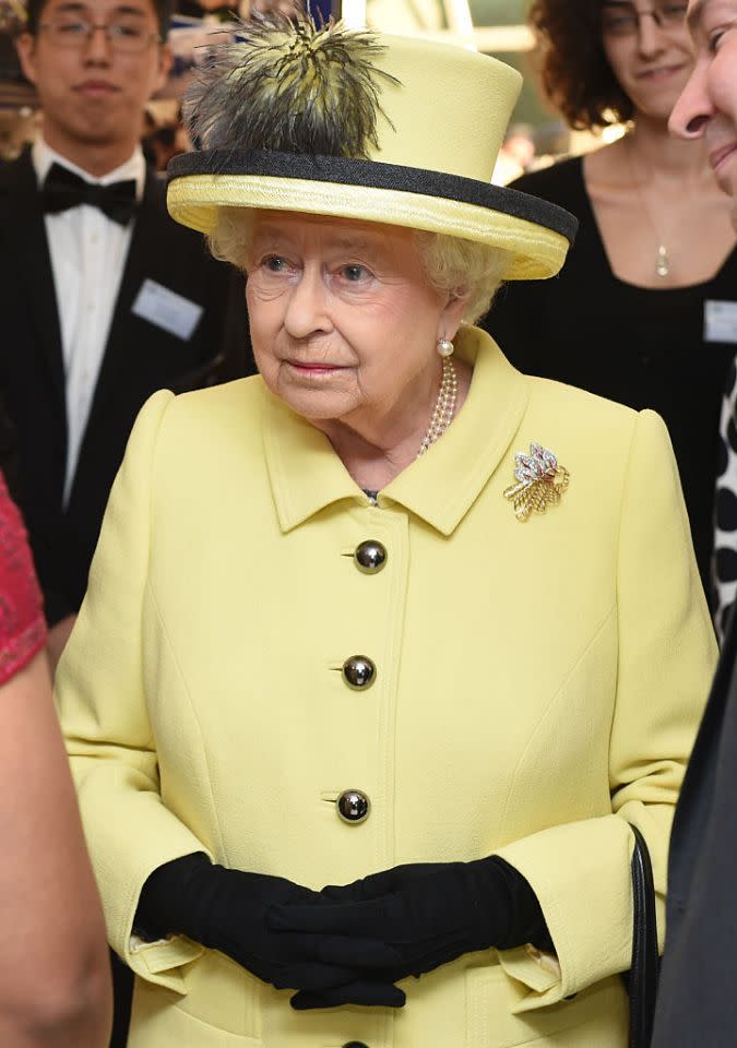 <p>En 2016, la reine portait un tailleur jaune pâle et un chapeau orné lors de sa visite à l’université de Londres. (Photo : Getty Images) </p>