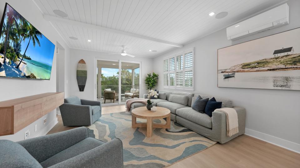 Light-filled living room of a Hunters Point home with a blue carpet and gray couches