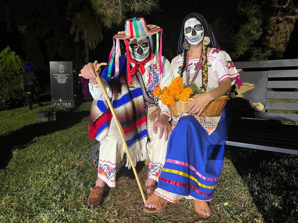 A couple taking a rest on a bench had eye-catching looks at the Día de Los Muertos celebration at the Hollywood Forever Cemetery in Los Angeles on Saturday, Oct. 28, 2023.
