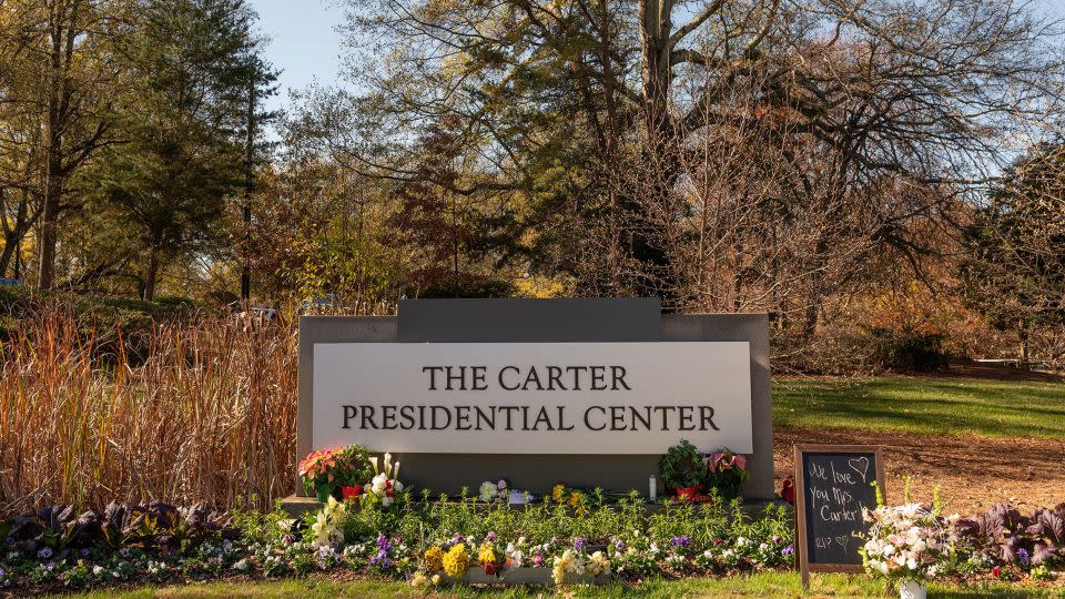 Λουλούδια τοποθετούνται στη βάση μιας πινακίδας στην είσοδο του Προεδρικού Κέντρου Carter στην Ατλάντα στις 27 Νοεμβρίου.  – Will Lanzoni/CNN