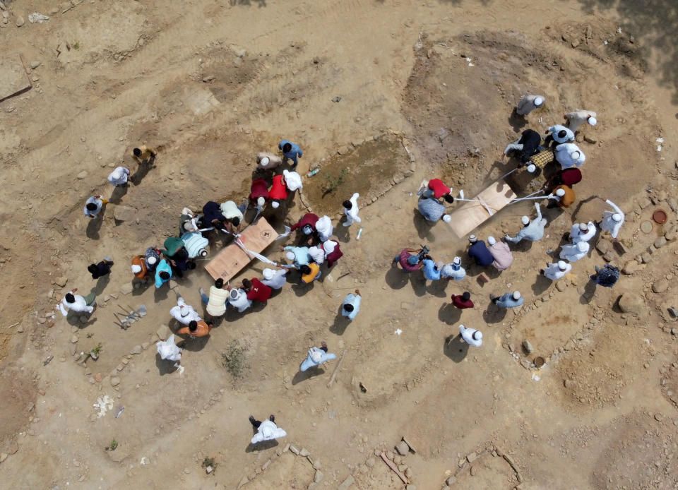People bury the bodies of COVID-19 victims at a graveyard in New Delhi on April 16, 2021.<span class="copyright">Danish Siddiqui—Reuters</span>
