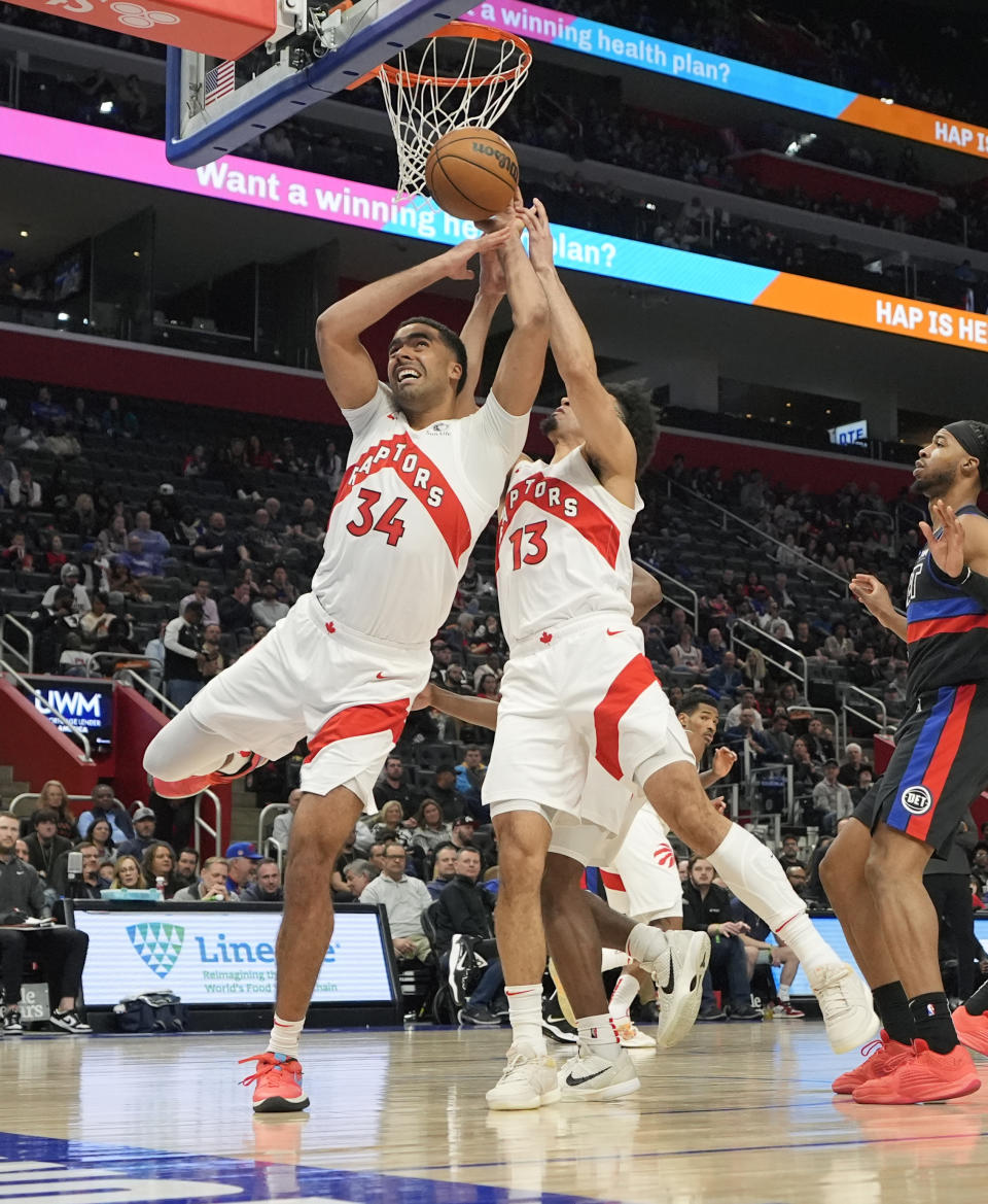 Toronto Raptors center Jontay Porter (34) and forward Jordan Nwora (13) reach for the rebound during the second half of an NBA basketball game against the Detroit Pistons, Wednesday, March 13, 2024, in Detroit. (AP Photo/Carlos Osorio)