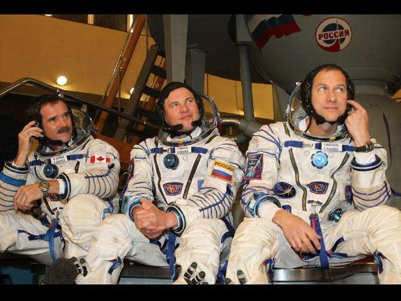 Expedition 34 Flight Engineer Chris Hadfield of the Canadian Space Agency (left), Soyuz Commander Roman Romanenko (center) and NASA Flight Engineer Tom Marshburn (right), shown here on Earth, flew in a Soyuz rocket to dock with the ISS on December 21, 2012.