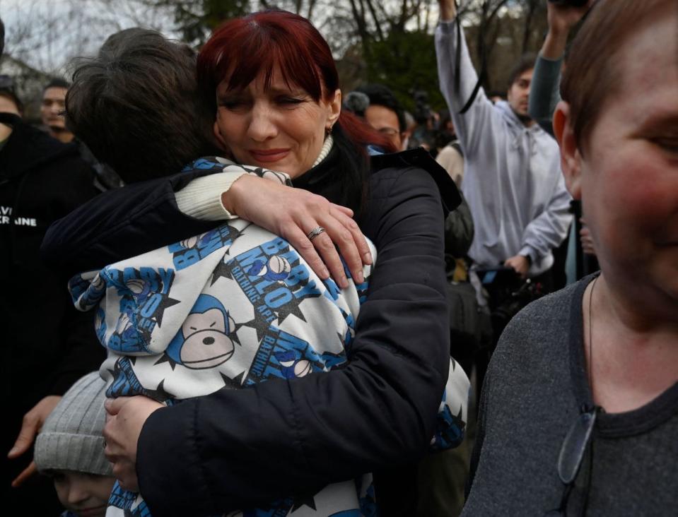 A Ukrainian woman meets her son after he and over a dozen other Ukrainian children were brought back from Russian-held territory to Kyiv on March 22, 2023. About 19,000 Ukrainian children have been identified as forcibly deported to Russia since the start of Russia's full-scale invasion of Ukraine in February 2022. (Sergei Chuzavkov/AFP via Getty Images)