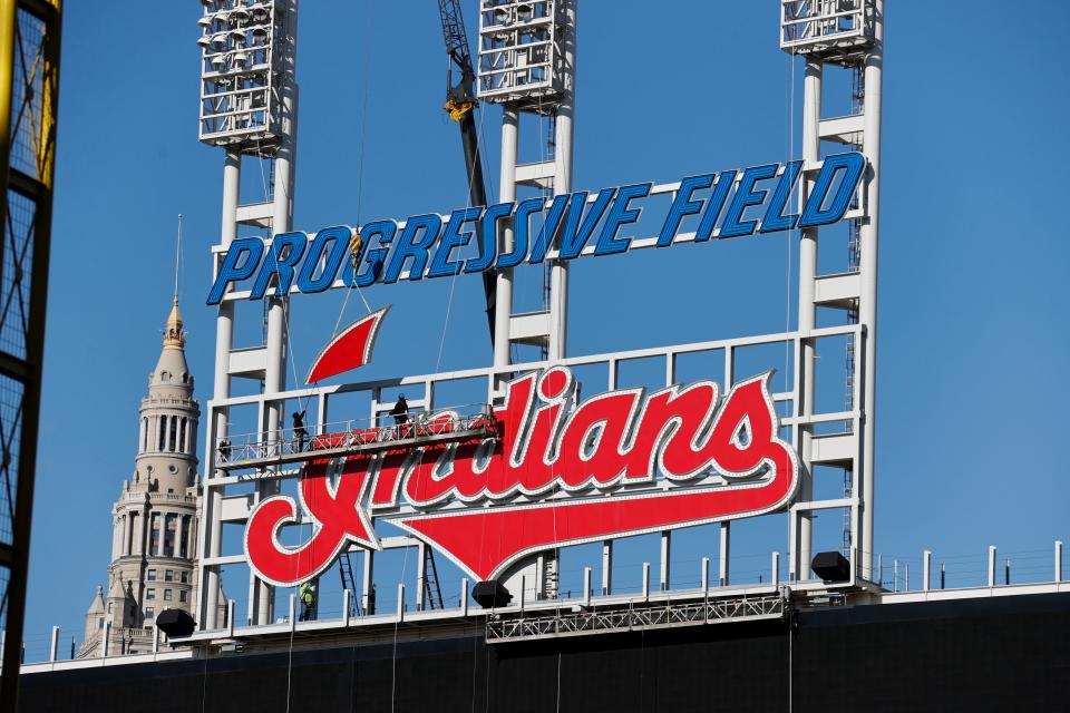 Workers begin to remove the Cleveland baseball team's old sign from above the scoreboard at Progressive Field, on Nov. 2, 2021.