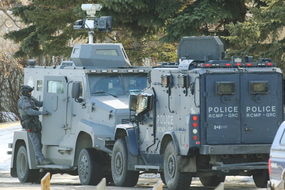 Calgary Police and RCMP tactical team members keep watch on a house where shots were fired yesterday. Residents of an east-end Calgary neighbourhood were being told to stay away as a standoff stretched into its second day, in Calgary, Alta., Friday, March. 15, 2024. THE CANADIAN PRESS/Dave Chidley