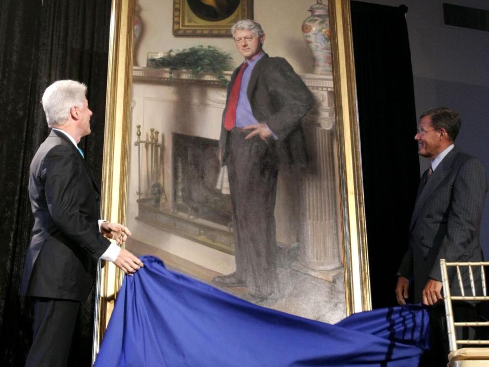 This April 2006 file photo shows former President Bill Clinton, left, looking up at his portrait after Lawrence Small, the secretary of the Smithsonian Institution, right, helped him remove the drape at the Smithsonian Castle Building in Washington. A Philadelphia artist said that his museum portrait of former President Clinton contains a shadow reference to Monica Lewinsky's infamous blue dress.