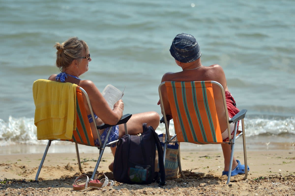 A couple enjoy the hot weather on the beach at Clacton-on-Sea in Essex (PA)