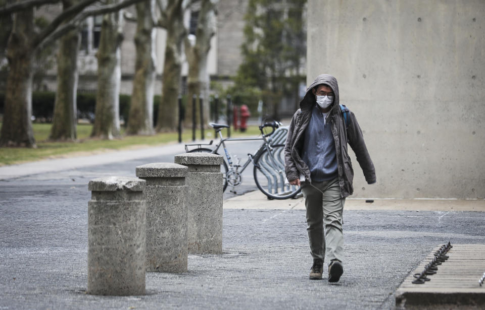 CAMBRIDGE, MA - MARCH 10:  CAMBRIDGE, MA - MARCH 10: A person wears a mask while walking though MIT's campus in Cambridge, MA on March 10, 2020. Some colleges have moved all classes online amid coronavirus concerns, but MIT has only moved its large classes and lectures offsite. (Photo by Erin Clark for The Boston Globe via Getty Images)