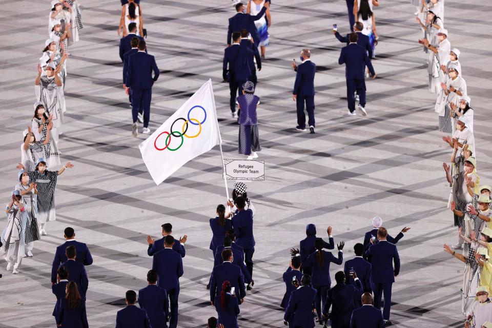 Flag bearers Yusra Mardini and Tachlowini Gabriyesos of the Refugee Olympic Team lead their team out during the opening ceremony.