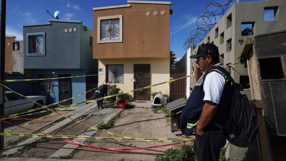 Xochitl Zamora, a friend of murdered journalist Lourdes Maldonado, collects her friend's pets from the crime scene and Maldonado´s home, as a security guard looks on, in Tijuana, Mexico, Tuesday, Jan. 25, 2022. - Marco Ugarte/AP