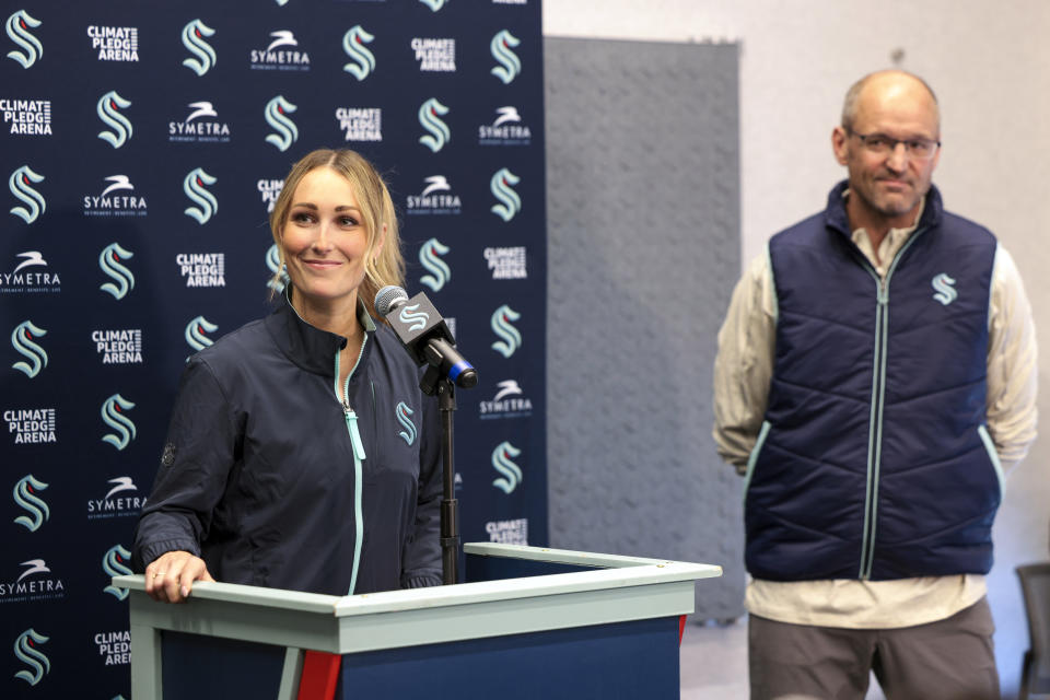 Seattle Kraken new assistant coach Jessica Campbell, left, speaks, as Kraken head coach Dan Bylsma listens during an NHL hockey press conference Wednesday, July 3, 2024, in Seattle. Campbell will become the first woman to work on the bench of an NHL franchise after the team hired her as an assistant coach Wednesday .(AP Photo/Jason Redmond)