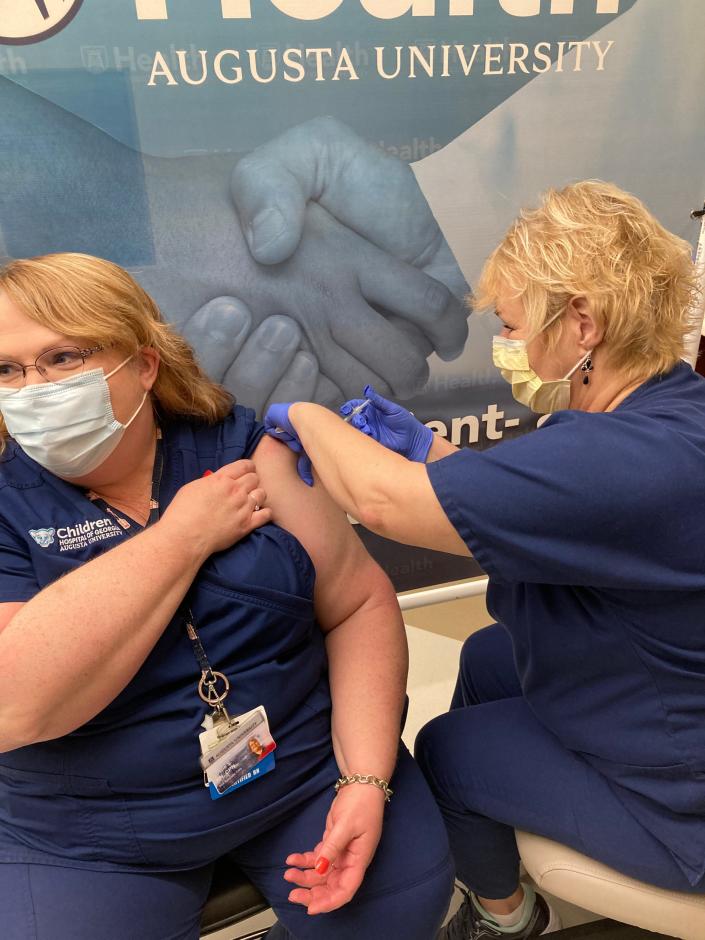 AU Health System nurse Leslie Slantis, left, receives a COVID-19 vaccine booster shot from Employee Health nurse Phyllis Hallman during an employee vaccination clinic on Aug. 26, 2021.