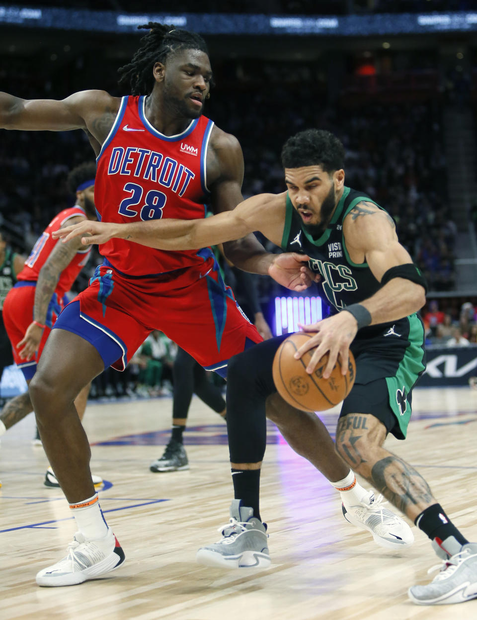 Boston Celtics forward Jayson Tatum, right, drives against Detroit Pistons center Isaiah Stewart (28) during the first half of an NBA basketball game Saturday, Feb. 26, 2022, in Detroit. (AP Photo/Duane Burleson)