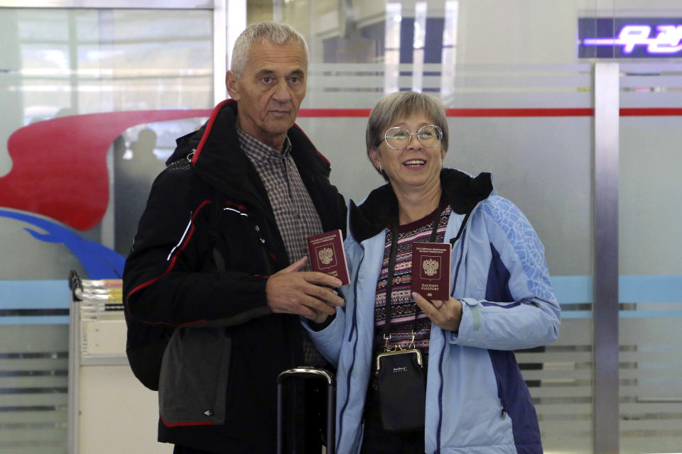 Tourists show their passports as a group of Russian tourists, likely the first foreign travelers from any country to enter North Korea since the pandemic arrive at the Pyongyang International Airport in Pyongyang, North Korea, Friday, Feb. 9, 2024. (AP Photo/Cha Song Ho)