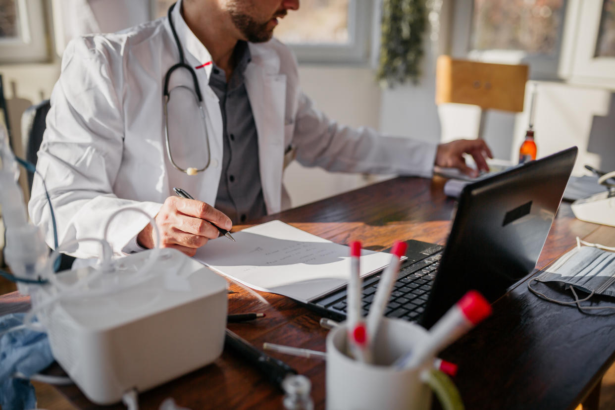 a busy doctor completes paperwork