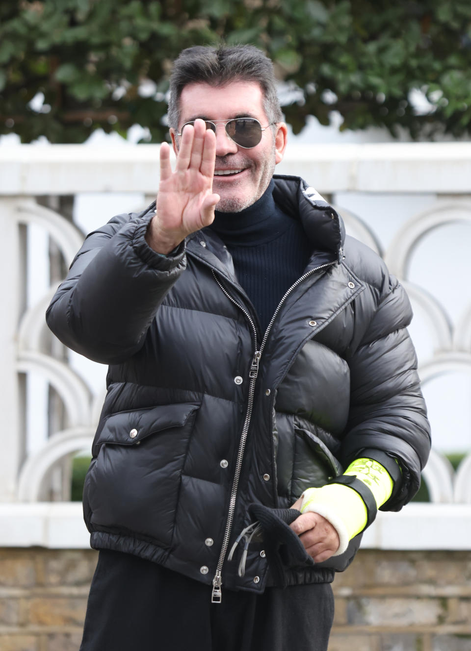 Simon Cowell looked in good spirits after leaving his house in London's Holland Park with a broken arm after suffering a bicycle injury last week. 