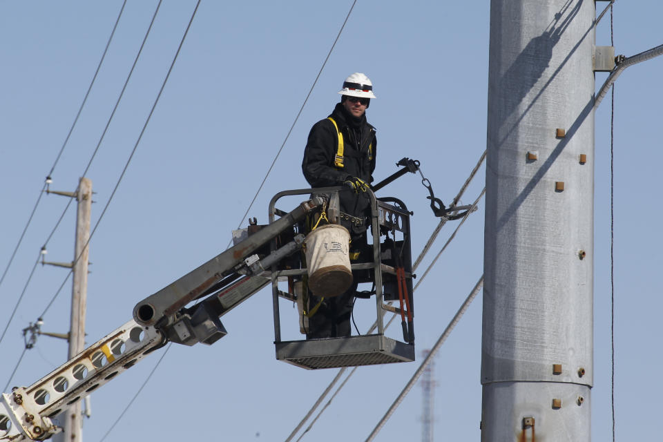 A communications lineman works on installing fiber optic lines on Friday, March 6, 2015 in Cranberry, Pa. (AP Photo/Keith Srakocic)