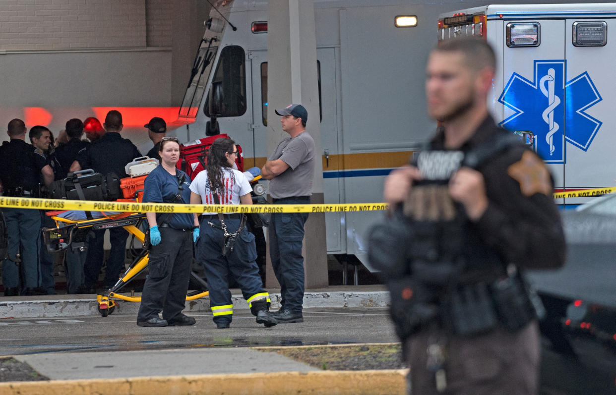 Emergency personnel and ambulances at a crime scene.