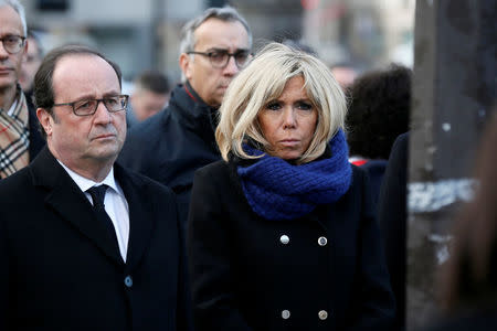 Former French President Francois Hollande (L) and Brigitte Macron, the wife of the French President, stand in front of a commemorative plaque facing the 'Le Carillon' bar and 'Le Petit Cambodge' restaurant during a ceremony marking the second anniversary of the Paris attacks of November 2015 in which 130 people were killed, in Paris, France, November 13, 2017. REUTERS/Etienne Laurent/Pool