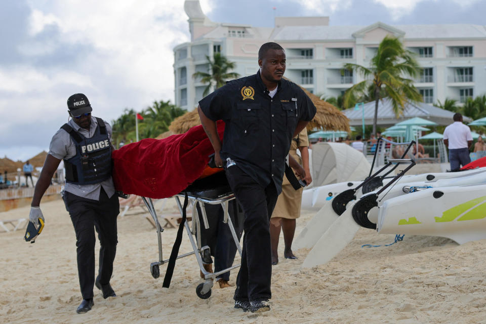 Mortuary services personnel transport the body of a female tourist after what police described as a fatal shark attack in waters near Sandals Royal Bahamian resort, in Nassau, Bahamas December 4, 2023. / Credit: DANTE CARRER / REUTERS