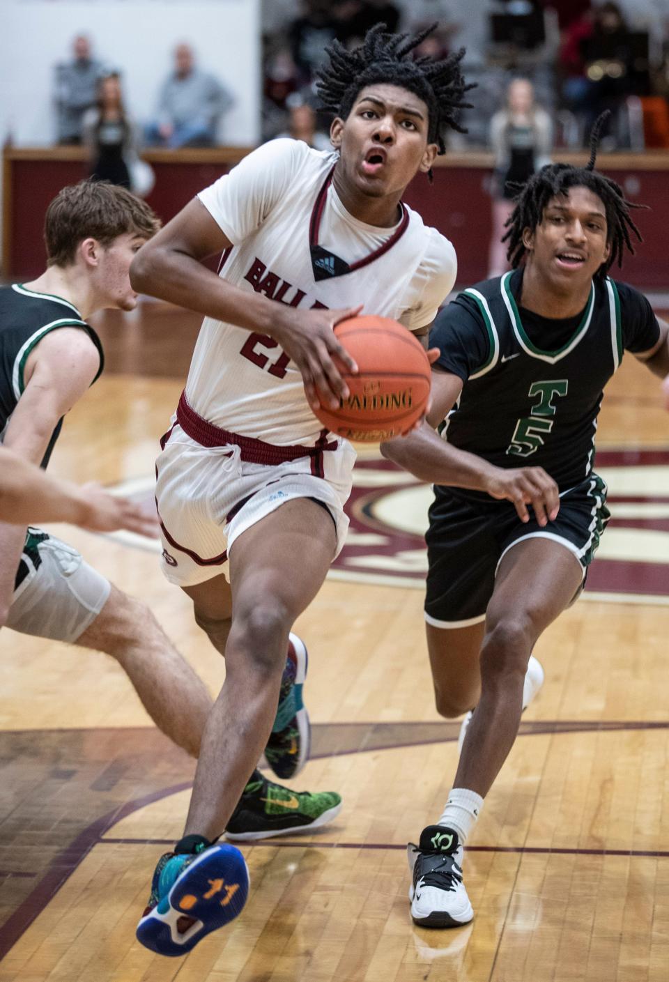 Ballard's Gabe Sisk drive past Trinity's Cam McClain during the Seventh Region quarterfinals game at Ballard High School. March 1, 2022