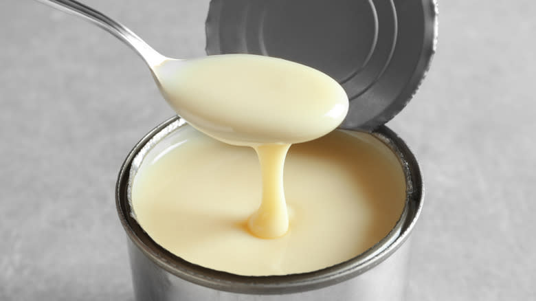 Spoon dipping into a can of condensed milk