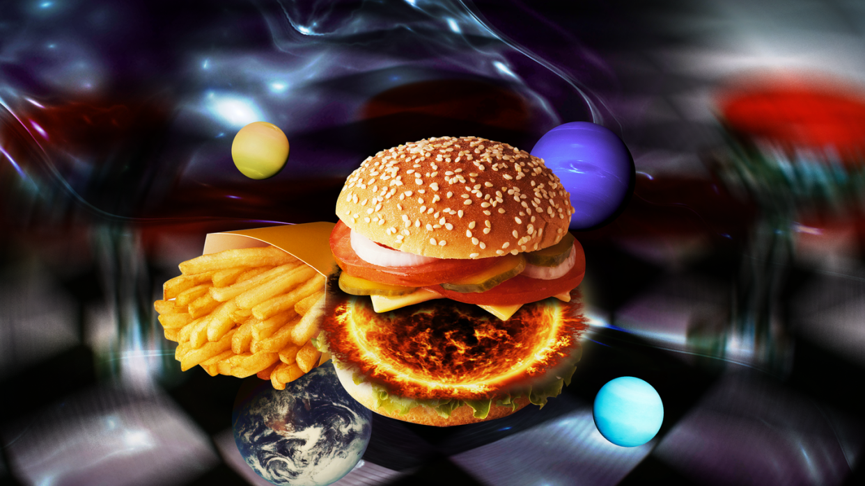 a hamburger and fries over a space themed background