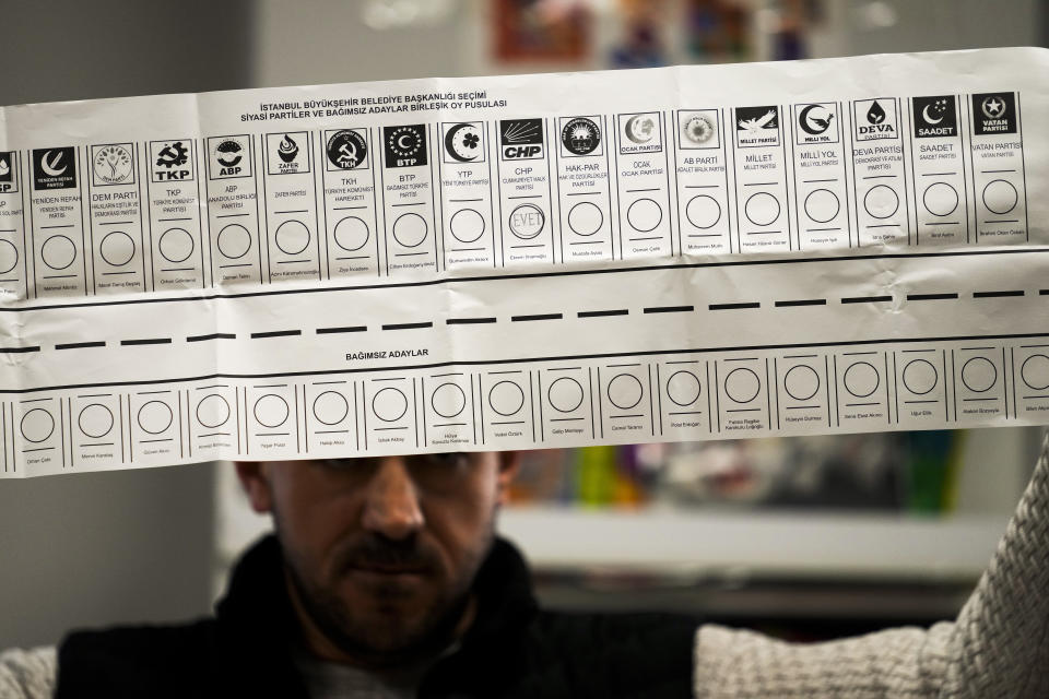 An election representative holds a ballot with a vote for Republican People's Party, or CHP, at a polling station in Istanbul, Turkey, Sunday, March 31, 2024. Turkey on Monday was coming to grips with the opposition's unexpected success in local elections that saw it outperform President Recep Tayyip Erdogan's ruling party and add to municipalities gained five years ago. (AP Photo/Emrah Gurel)