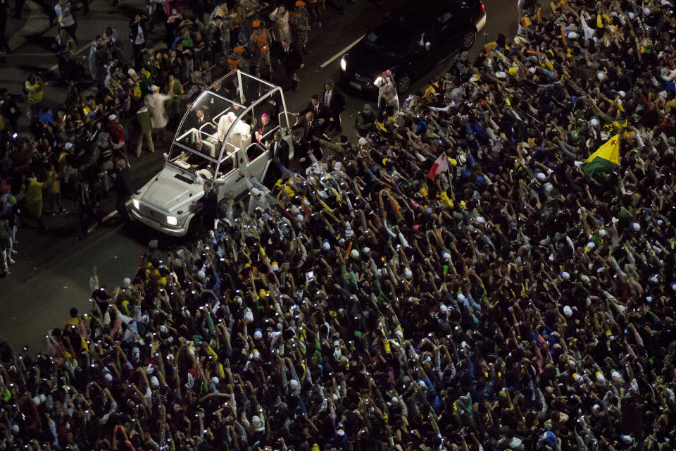 FILE -- In this file photo taken on the Copacabana beachfront in Rio de Janeiro, Brazil, on July 25, 2013, Pope Francis greets from his popemobile as he makes his way through the crowds. Francis' flouting of rules has extended to saints (he's declared three of them without going through the Vatican's miracle-confirmation protocol) and to security: He ditched the armored popemobile for his first foreign trip to Brazil, and promptly got swarmed by adoring crowds in Rio when his motorcade took a wrong turn. (AP Photo/Felipe Dana)