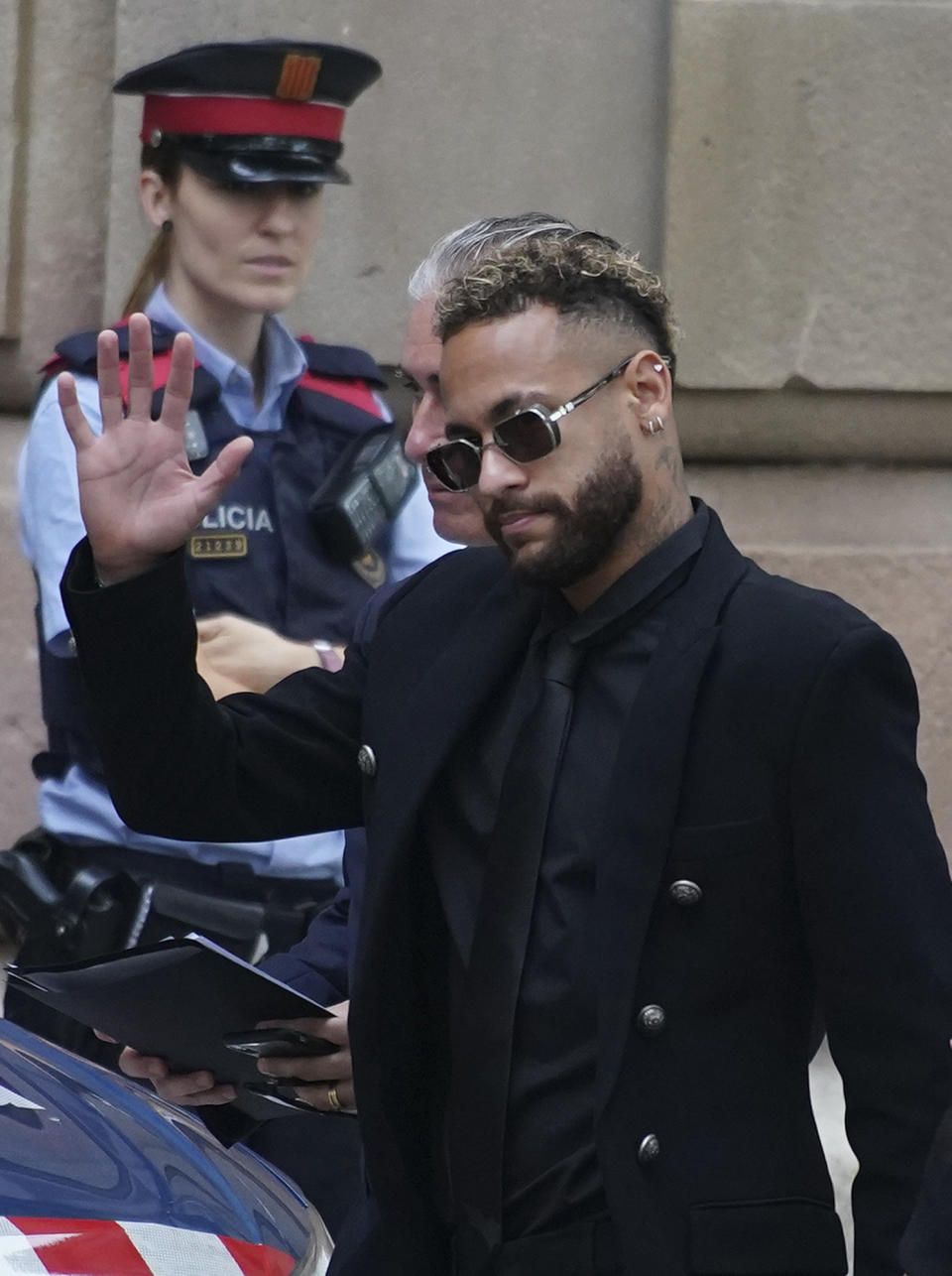 Former FC Barcelona player Neymar who now plays for Paris Saint-Germain waves on arrival at a court in Barcelona, Spain, Monday Oct. 17, 2022. Neymar returned to Spain Monday to face trial on fraud charges regarding his 2013 transfer from Santos to FC Barcelona. The Brazilian forward, his father, and the former executives of Barcelona and Santos are accused of hiding the true cost of his transfer with the alleged goal of cheating a private Brazilian company.(AP Photo/Joan Mateu Parra)