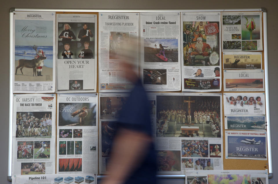 Some front pages and section fronts of the Orange County Register are seen in the newsroom in Santa Ana, Calif., Thursday, Dec. 27, 2012. After years of demoralizing layoffs, one newspaper is trying something novel: hiring more reporters. The Orange County Register’s new owner thinks the way to turn the paper around is through better reporting to lure new and former readers to a revived product. (AP Photo/Jae C. Hong)