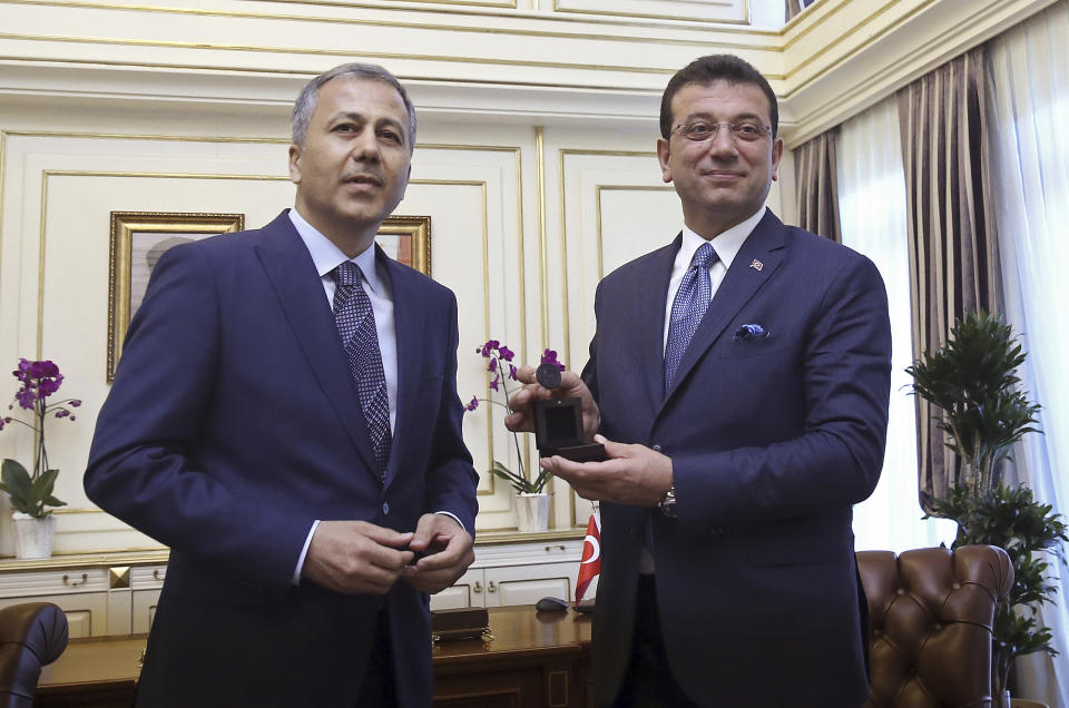 Ekrem Imamoglu, the candidate of Turkey's main opposition Republican People's Party, right, smiles after taking office from Istanbul Governor and Interim Mayor, Ali Yerlikaya, in Istanbul, Thursday, June 27, 2019. Imamoglu is formally taking office as mayor of Istanbul four days after he won a repeat election in Turkey's largest city and commercial hub. (Imamoglu Team via AP, Pool)