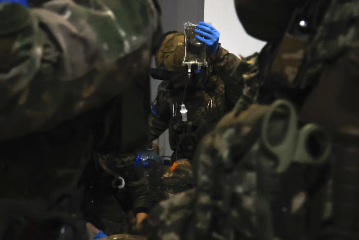 Ukrainian servicemen administer first aid to a wounded soldier in a shelter in Soledar, the site of heavy battles with Russian forces in the Donetsk region, Ukraine, Sunday, Jan. 8, 2023. (AP Photo/Roman Chop)