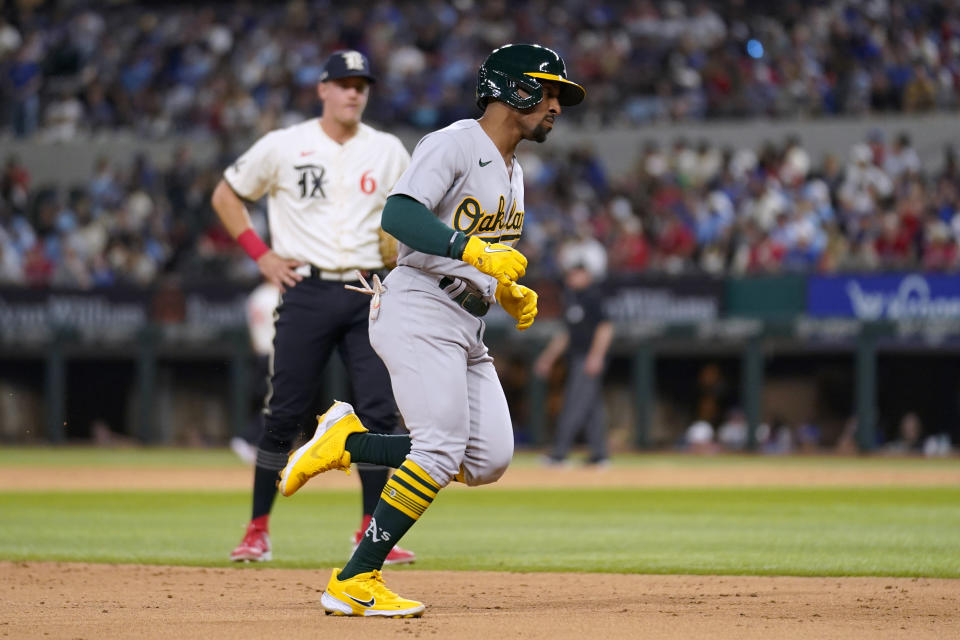 Oakland Athletics' Tony Kemp rounds third past Texas Rangers' Josh Jung on a solo home run during the fifth inning of a baseball game Friday, April 21, 2023, in Arlington, Texas. (AP Photo/Tony Gutierrez)