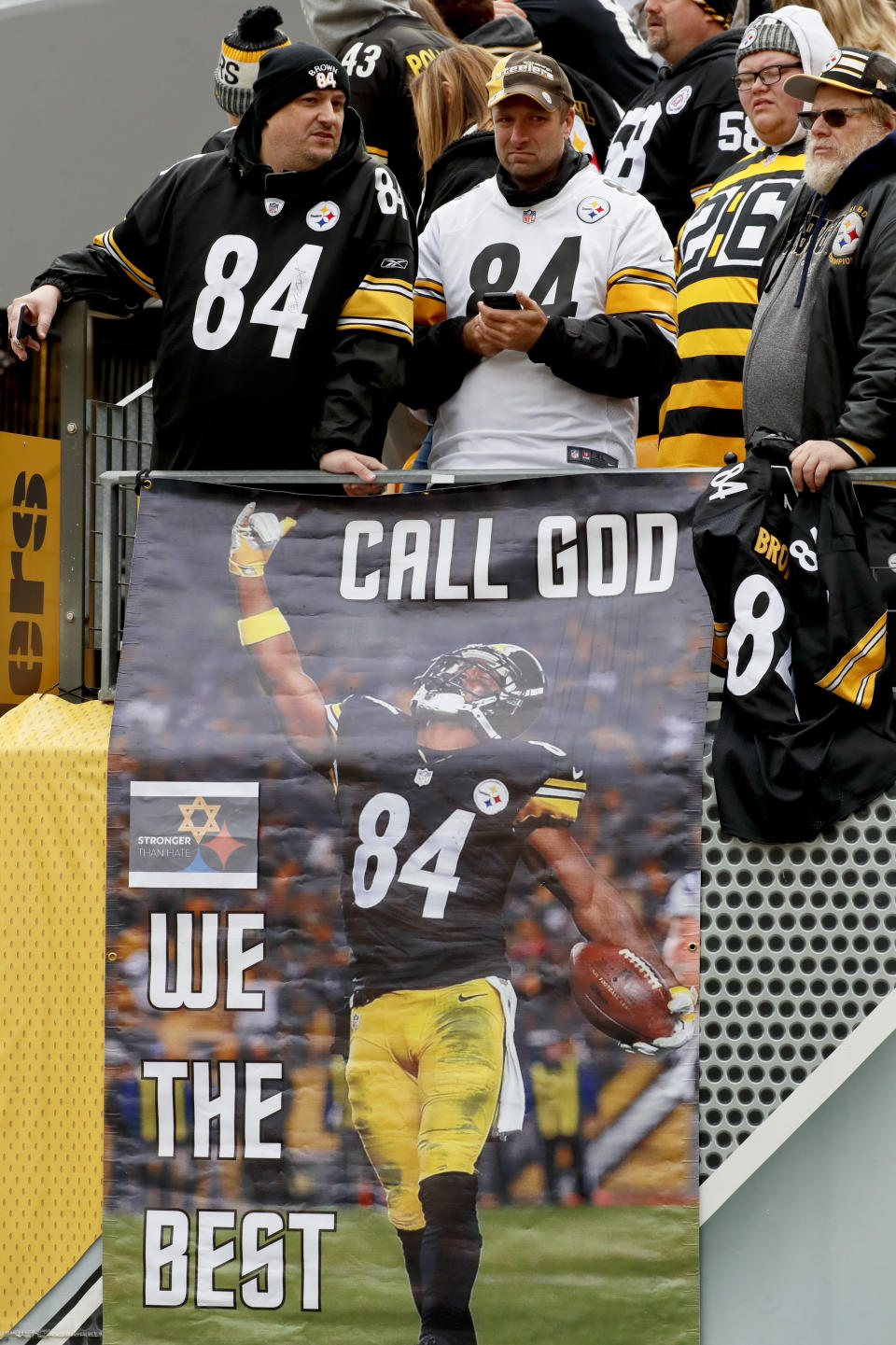 Fans stand above a banner with a Pittsburgh Steelers logo that has one of the hypocycloids changed to a Star of David at Heinz Field for an NFL football game between the Pittsburgh Steelers and the Cleveland Browns, Sunday, Oct. 28, 2018, in Pittsburgh. The Steelers added the logo in respect for the victims of a deadly shooting in a Pittsburgh synagogue on Saturday. (AP Photo/Gene J. Puskar)