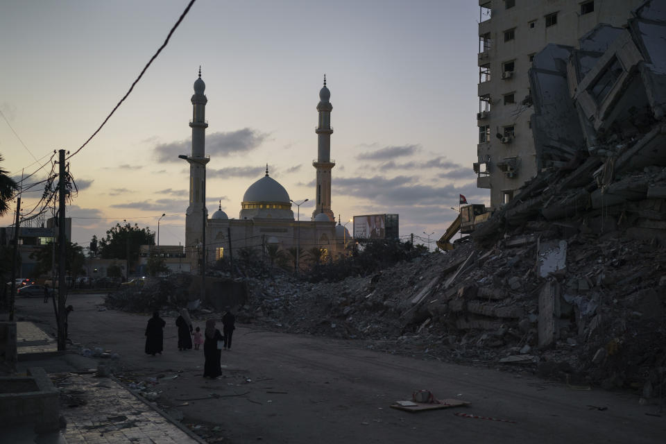 Palestinians walk next to the rubble of a building destroyed by an airstrike during an 11-day war between Israel and Hamas, the militant group that controls Gaza, in Gaza City, Thursday, June 10, 2021. (AP Photo/Felipe Dana)
