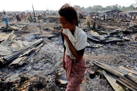 A woman walks among debris after fire destroyed shelters at a camp for internally displaced Rohingya Muslims in the western Rakhine State near Sittwe, Myanmar May 3, 2016. REUTERS/Soe Zeya Tun