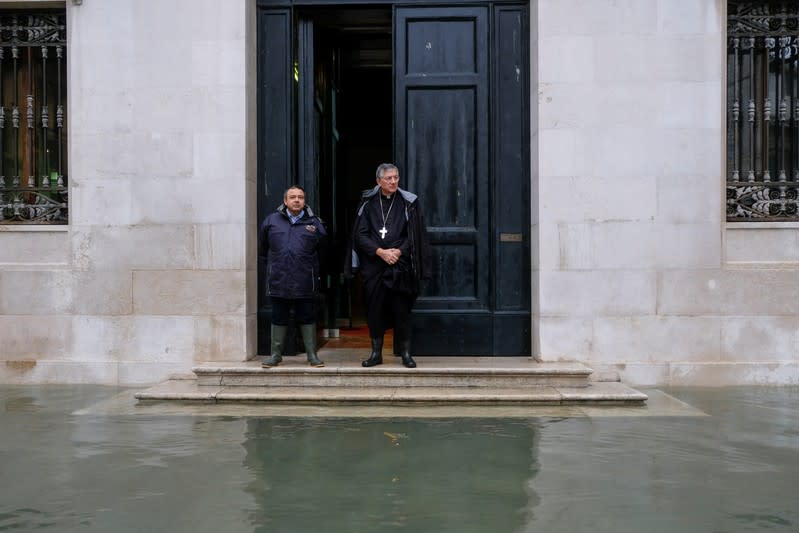 The Patriarch of Venice stands at the entrance of St Mark's curia during an exceptionally high water levels in Venice