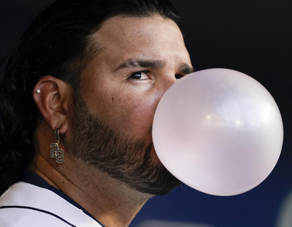 Seattle Mariners' Eugenio Suarez blows a bubble in the dugout before the team's baseball game against the Cleveland Guardians on Saturday, April 1, 2023, in Seattle. (AP Photo/Lindsey Wasson)